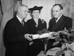 J. R. Edwards, left, new president of the club, is shown with Mrs. Edwards and Everett Cline, the retiring president