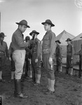 Military training at Camp Bowie, Brownwood, Texas, World War II; 2nd Lieutenant O.C. Stovall of Company B, 111th Engineers, inspects rifle of Private Harry McKinney