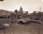 Camp Bowie, Brownwood, Texas, World War II; Private Raymond Slaughter, Private Norvell Few, and Sgt. Harold Griffith pull angle dozer out of supply line for road building at Camp Bowie