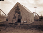 Camp Bowie, Brownwood, Texas, World War II; 2nd Lieutenant Terrell J. Davis, supply officer of Third Battalion, 142nd, adjusts fly on tent