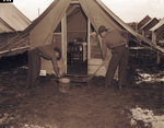 Camp Bowie, Brownwood, Texas, World War II; Private Eddie Grossman, left, of Medical Detachment, 111th Engineers, and Pvtg. Rudolph Georgia swab front step of officer's quarters