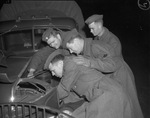 Private P.E. Stone, Private G.W. Reichle, Sergeant Bill Watson, and Private Claude Thomas Jr. work on trucks