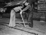 Chester Samples (left) and Floyd Messenger prying up old yellow pine car tracks on Seventh Street