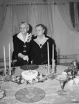 Mrs. M. A. Reeder (left) cutting her eightieth birthday cake