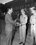 Amon Carter Jr. shown presenting team championship trophy to Cadet Major Jimmy Vickery, captain of the city's top ROTC rifle team at Poly High