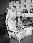 Frank A. Carriher posed beside furniture in furniture and appliance store