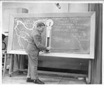 Robert Denny, one of three Weather Bureau employees at WBAP-TV, does a "Weather Tele-facts" program at the studio's weather map
