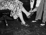 Emmins McCord's hands shown applying shoe-shine to Alice Ward's shoes