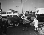 Mrs. James Pointers holding Frances Kathleen, trying to clear traffic so the Francis Baker and Jeraldine Doyle can cross streets