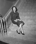 Miss Carolyn Cox, daughter of Mr. and Mrs. . E. Cox Jr., shown sitting on stairs