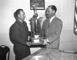 Lieutenant Colonel V. V. Laughlin, head of the city schools' Reserve Officer's Training Corp units, receiving the new city championship rifle team trophy from Amon Carter Junior