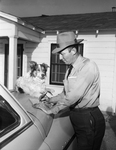Julian C. Parker shown with dog, "Nobby" who follows him on his mail route