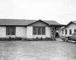 Mr. and Mrs. Pete Carpenter and son standing on porch of their new home, Fort Worth, Texas