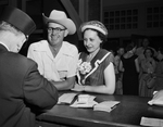 Mr. and Mrs. Cleat Cockrell, having tickets checked by Pullman Conductor C. R. Condit before boarding train to Mexico City