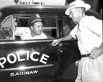 Policeman Leslie Long talks with C. B. McDaniel