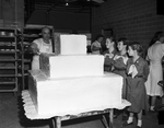 Girl Scouts, Karen Heitt, Jane Lemon and Evalie Hawes watch Leonard's baker Vance Suchocki finish a 300-pound cake for the Girl Scout round-up