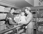 Mrs. Chester J. Emrie looks at a suit for her son