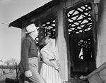 Mrs. McCabe andÂ C. C.Â Makarwich view burned house