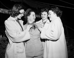 Three singers from Clifton admire a corsage worn by Mrs. Jim Standefer