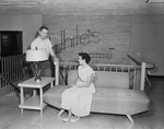 White's Auto Store. Leonard Turner, manager of the furniture department and Wanda Halverson, office employee looking over furniture in new store in the Fair East Shopping Center