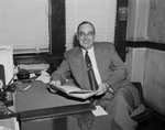 Charles E. Nash shown at his desk