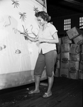 Mrs. Jean Emerson demonstrates hand painting of plastic shower curtains at branch plant of Styletone, Inc.