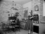 Mrs. Gordon W. Smith in her kitchen with her mother Mrs. E. E. Taylor, 3232 Avondale Avenue, Fort Worth, Texas
