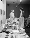 Sculptor Evaline Sellors demonstrates potter's wheel to Etta Mae Brown