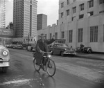 Arlie D. Robinson riding a bicycle in downtown Fort Worth