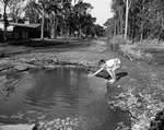 Bill Jordan, measuring water in a street after a water main break