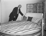 Max Harper, mgr. Sleep Exay Mattress Co. with mattress at new showroom