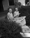 Donna and Ronna DeVoll, twins, carrying Star Telegram