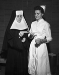 Miss Sherry Lynch accepts her diploma Friday night from Sister M. Dorothea