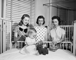 Mimi Wier, shows Susan Moody and Judy Franklin of the fun and pleasure derived from volunteer work in the pediatric ward of Peter Smith Hospital by Bob Bain