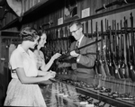 Mrs. Jim Perdue and daughter, Mary, looking at guns