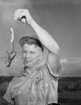 Bill D. Brock, Mobil Service Station worker, holding crayfish found on driveway of station