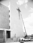 St. Joseph Hospital annex with cross being installed on front