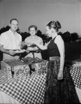 Mrs. J. P. McClure, right, serving Edwin B. Hibbs and Mrs. Mal Rumph at Peter Smith Hospital Aux. barbeque