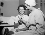 Mrs. Woody Beaty, left of Breckenridge, examines small instruments used to enlarge heart valve. Nurse Mrs. C. C. Fermin, holds instrument