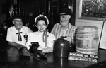 H. D Field Junior, Mrs. S. J. Pedigo, and Lewis Lauderdale, stand in the Stonewall Saloon by Tony Slaughter
