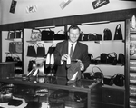 L. L. Burchfield, manager of the shoe department at Cheney's, display shoes and bags offered at a discount price