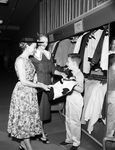 Mrs. Tom Auffenberg and Her Son Tommy Look at Jackets with Saleslady Mrs. J. W. Boone