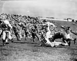 Texas Christian University (TCU)-Kansas football action. Jack Reding, 16, with ball with R. E. Dodson, 38, Texas Christian University (TCU) and William Allen, 81, coming in for tackle by Al Panzera