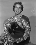 Mrs. H.C McCleary, chairman of Pro American silver anniversary committe displaying holiday wreath