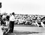 Texas Christian University (TCU)-Texas A&M football game. Series of Jim Meyers at game with players and Bud Sherrod. Meyers shouts encouragement to combatants by Joe McAulay