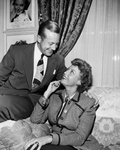 Jeanette MacDonald and Gene Raymond on couch by John Mazziotta