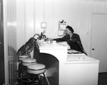 Mrs. J. A. Bond in kitchen with her dog, Sandy