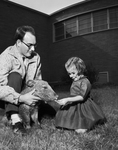 Children's Museum Curator John R. Preston holds Wofford, the pet javelina, as Janet Harrell pets her