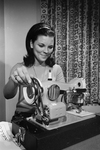 Cathy Capps with sewing machine, prize in Miss Teen-Age Fort Worth contest by Dale Blackwell
