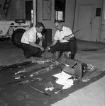 Wendell Sowell and George Brown examining weapons taken from Robert Maclin's home